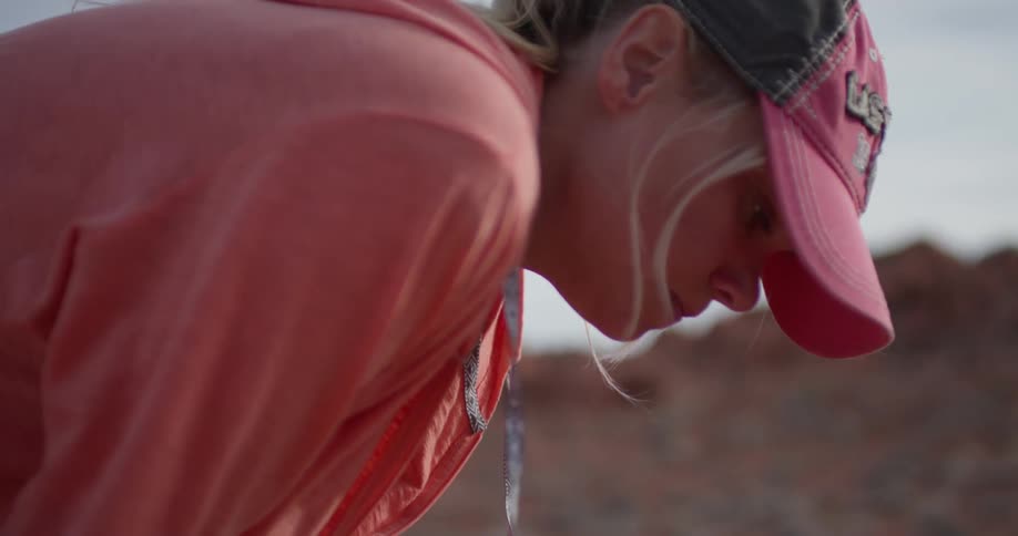 A woman exhales while leaning over to gather her breath