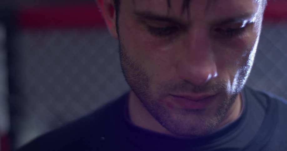 A man looks down while inside an mma ring