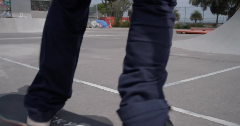 A man is flipping his skateboard as he rides outside on a sunny day