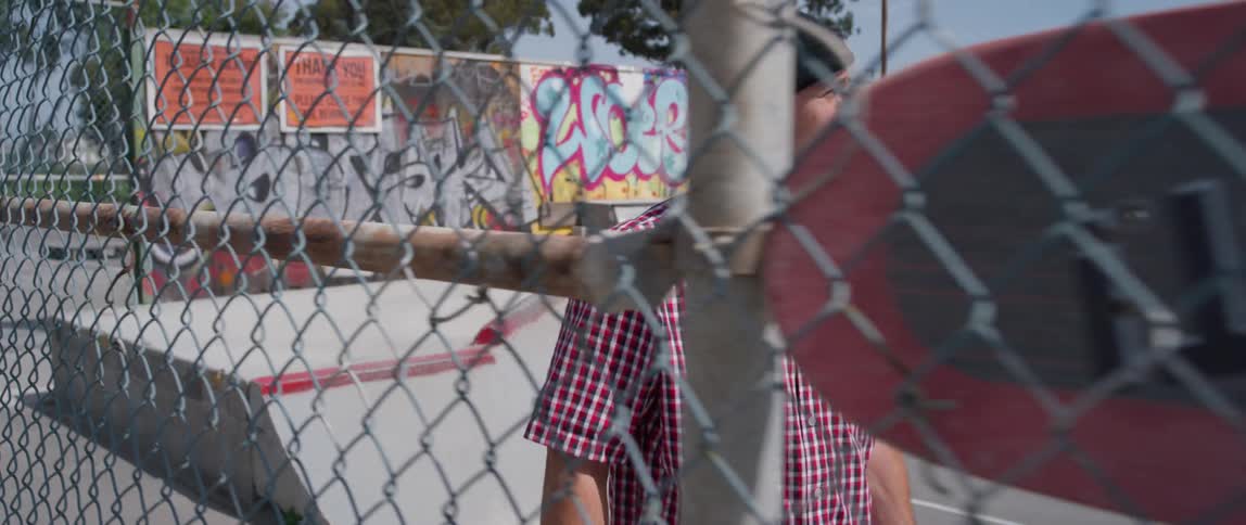 A man walks inside a skate park fence