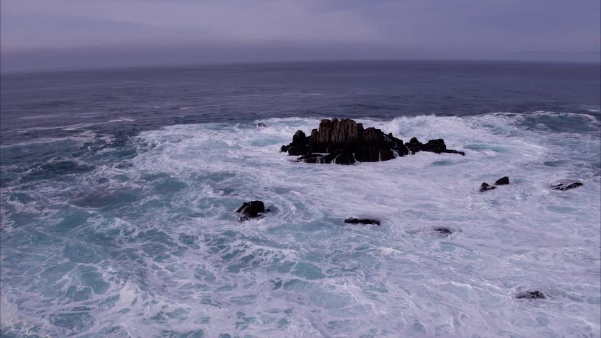 The large waves consume the rocks