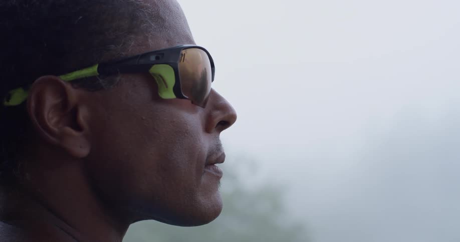 A man looks out into the haze from the hill