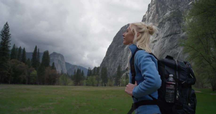 A woman hikes at the base of a mountain