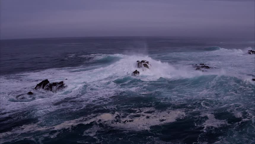 Ocean waves crash into rocks
