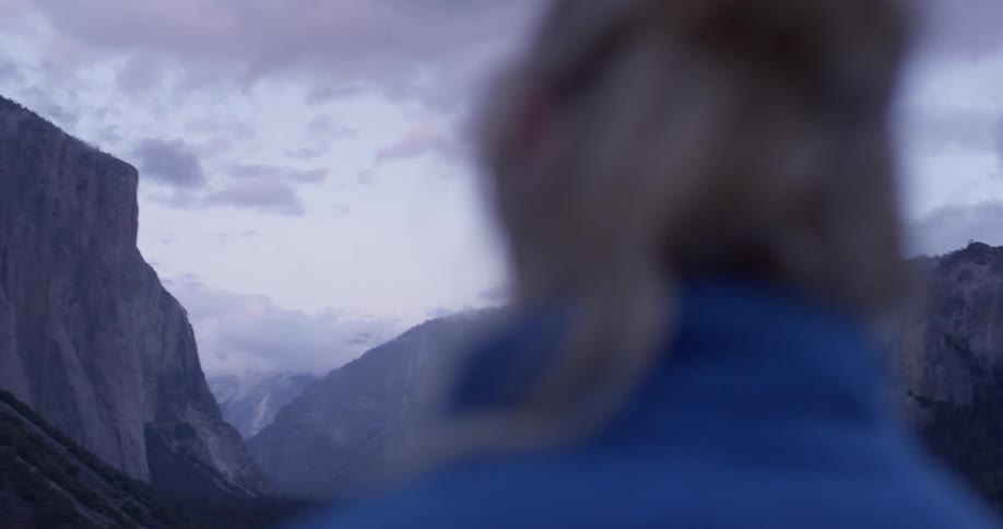 A woman looks up towards the mountains