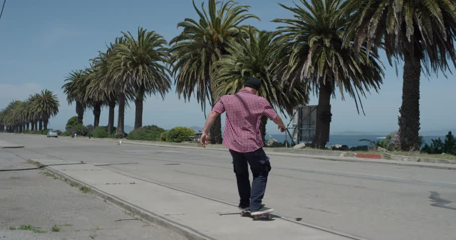 A person skateboards on the sidewalk