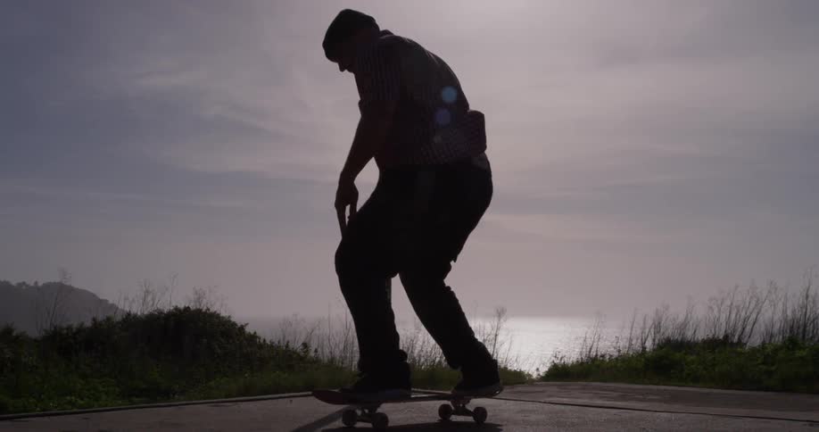 A man jumps onto a skateboard
