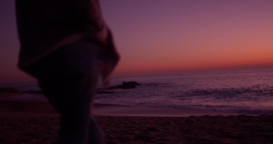 Woman stands on the beach as the waves roll in