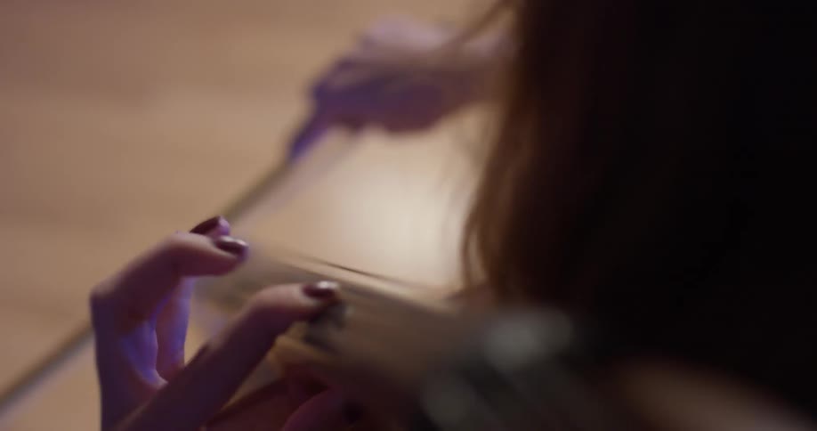 Woman pulls bow across cello strings