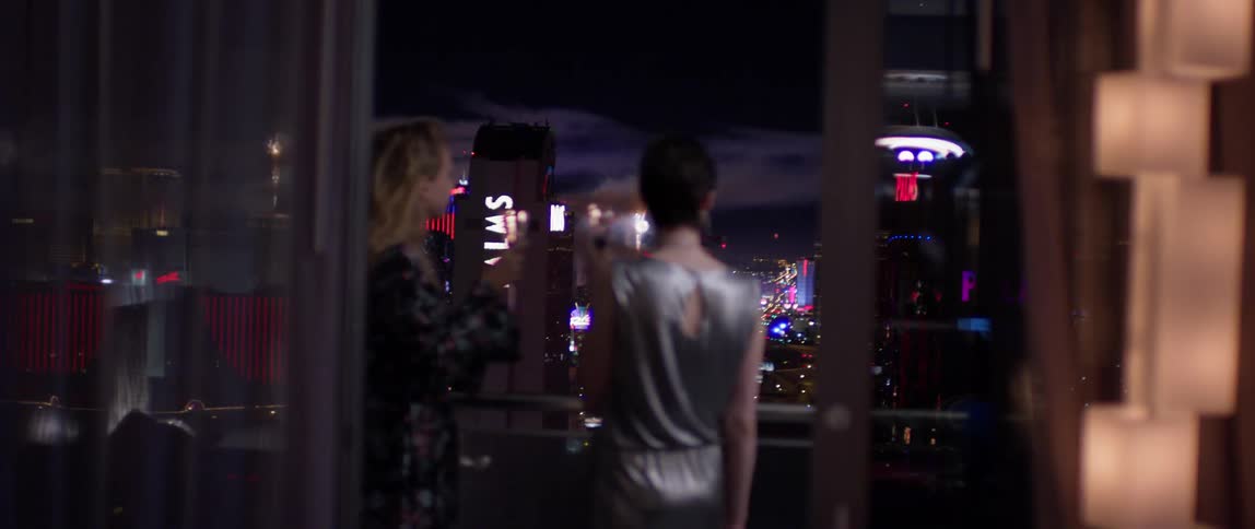 Two women drink on the balcony watching fireworks