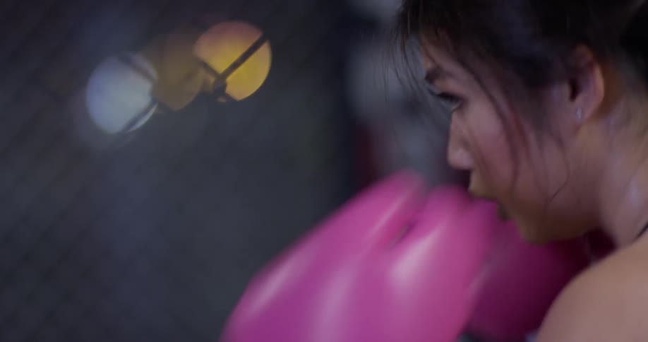 The woman is sparring in the gym