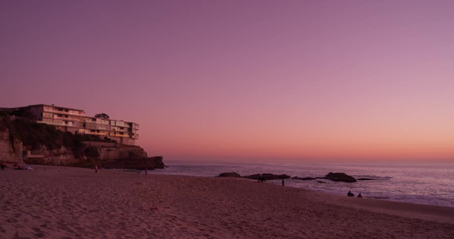 People sit on the beach at sunset