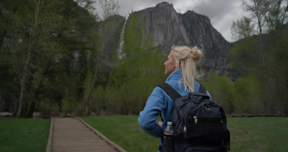 A woman is hiking towards the mountain