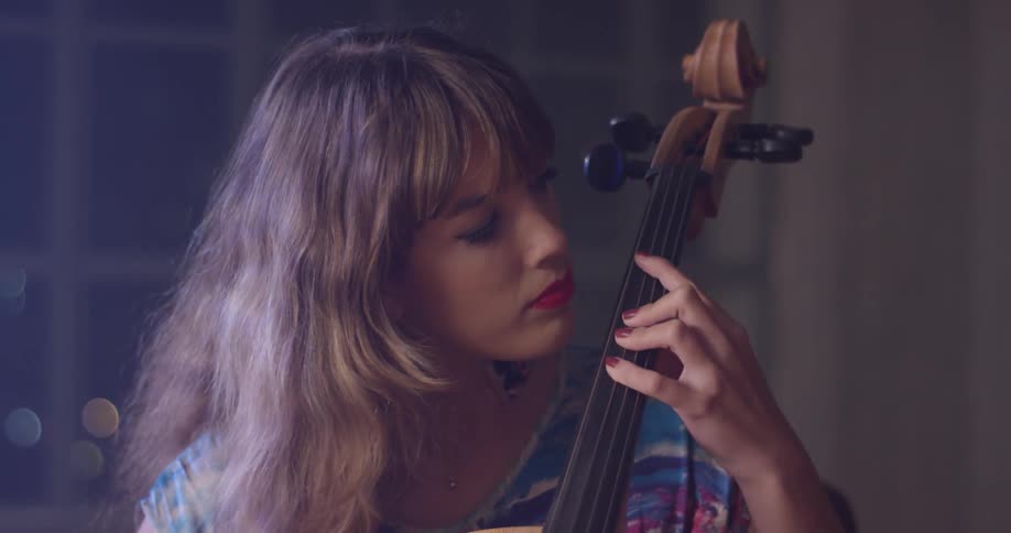A woman plays the instrument as she sits