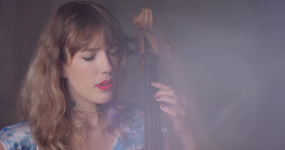Woman plays a cello in a brightly lit room