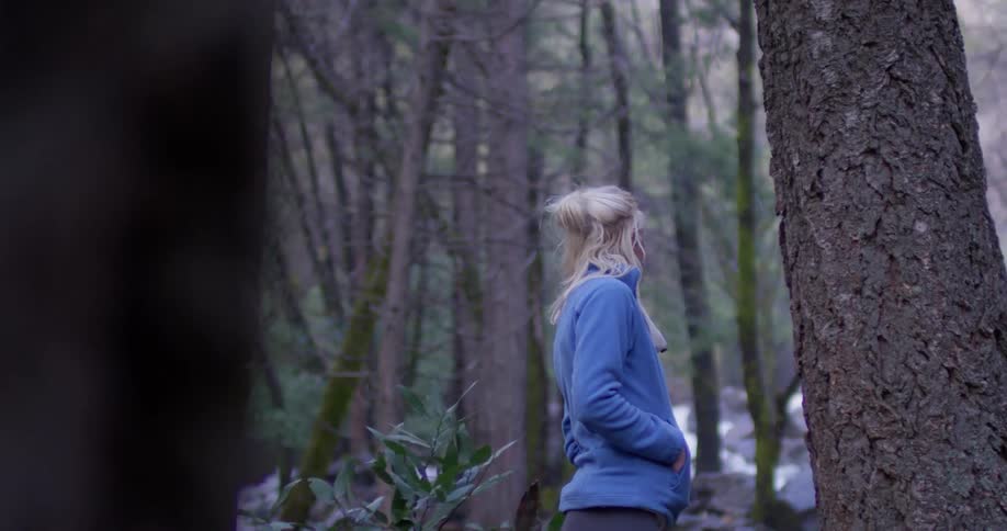 A woman hikes alone in a forest