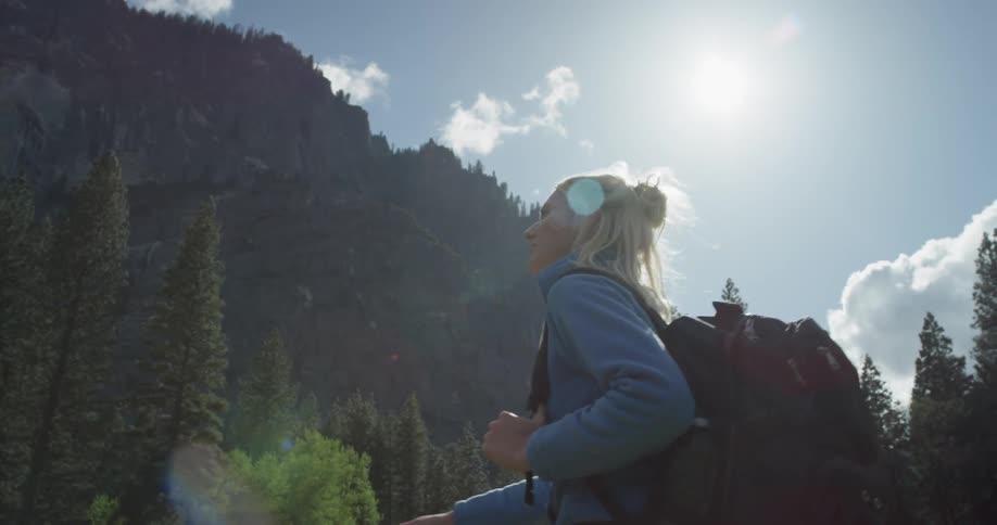 A woman is looking up as she hikes