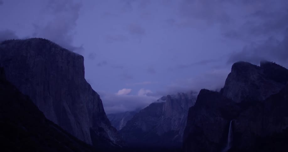 Clouds float above tall mountains