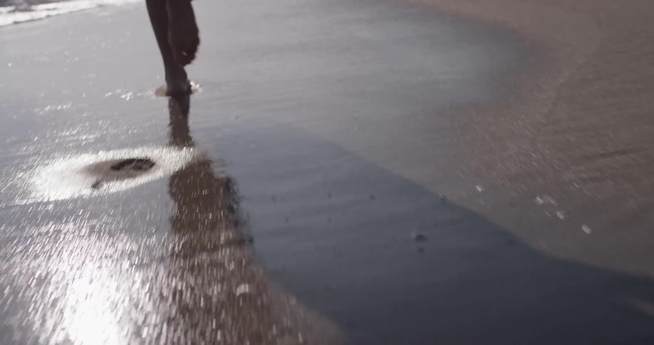 A person jogs on the wet sand