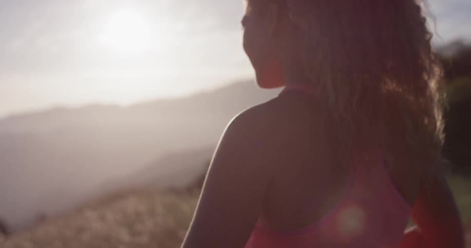 A woman arches her back on a mountain path