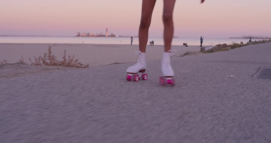 A woman roller skates near the beach