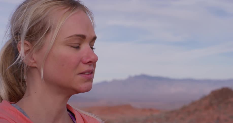 Smiling woman looks out over rocky hills
