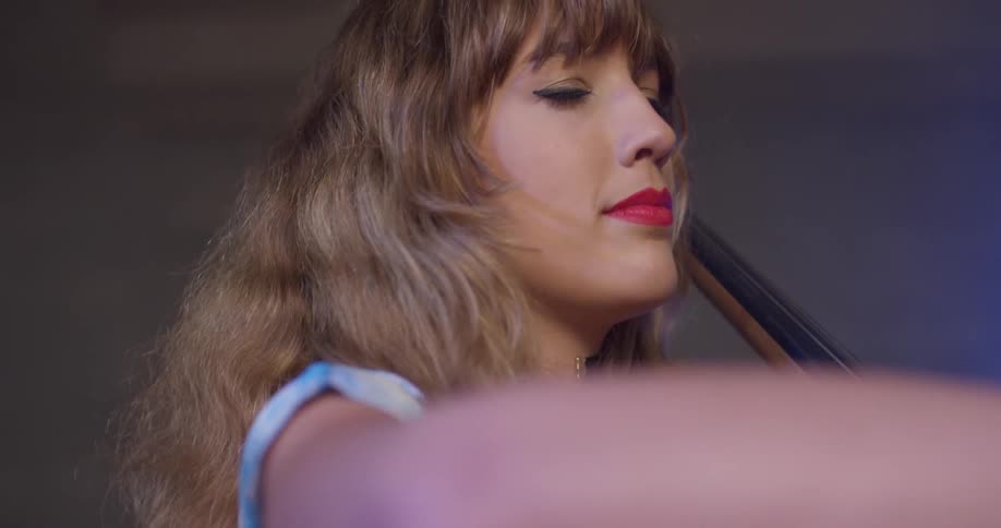 A woman smiles while playing a cello