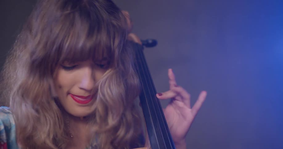 A woman is smiling as she plays the instrument