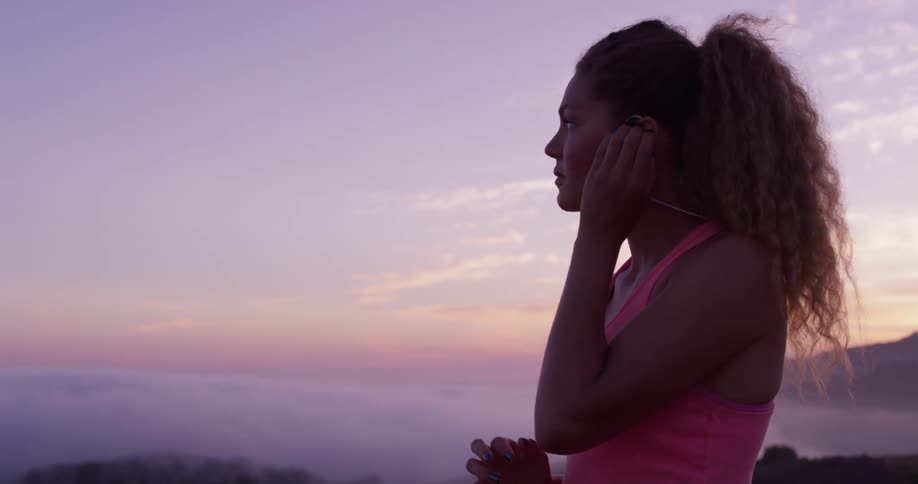 A woman exercises in mountains at sunset