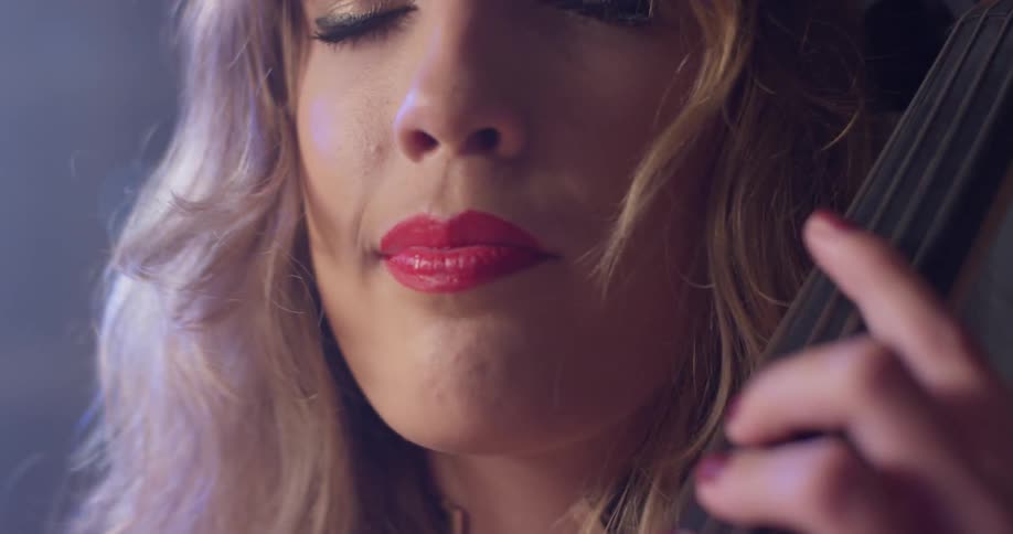 A woman is holding a musical instrument and playing