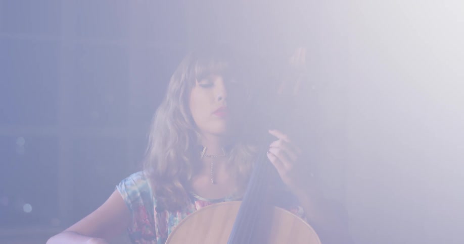 Woman plays the cello in a brightly lit room