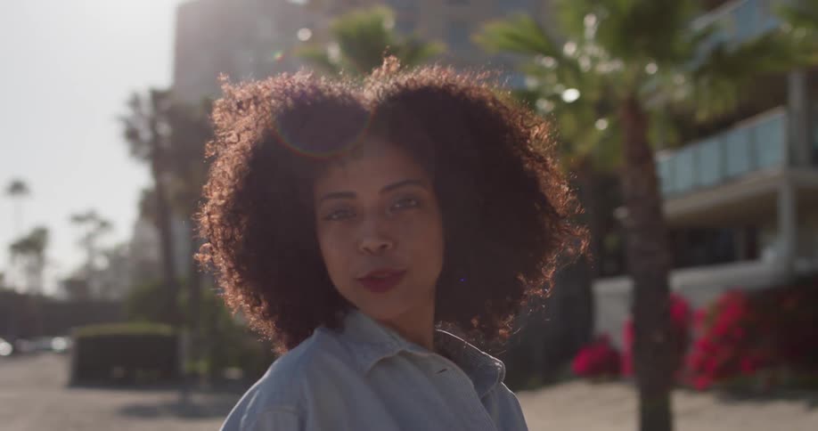A woman smiles outside under the sun