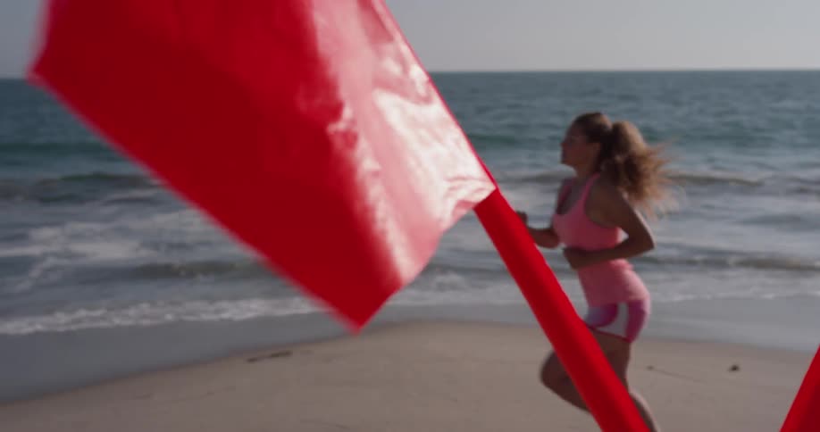 A woman jogs on a sandy beach