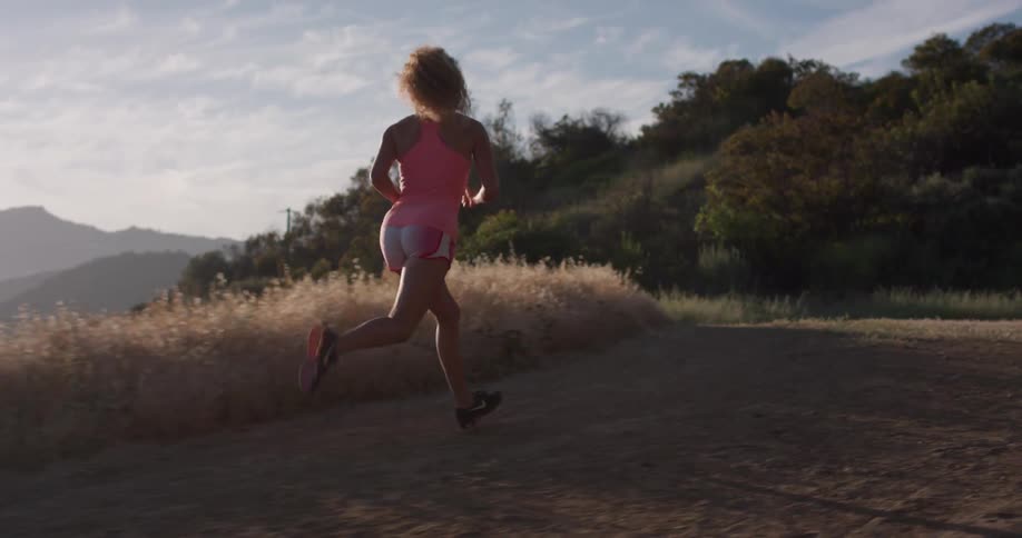 A woman jogs on a dirt trail