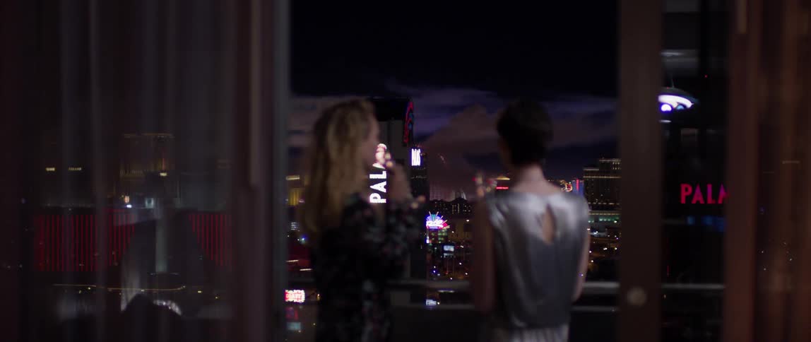 Two women drink champagne in las vegas at night