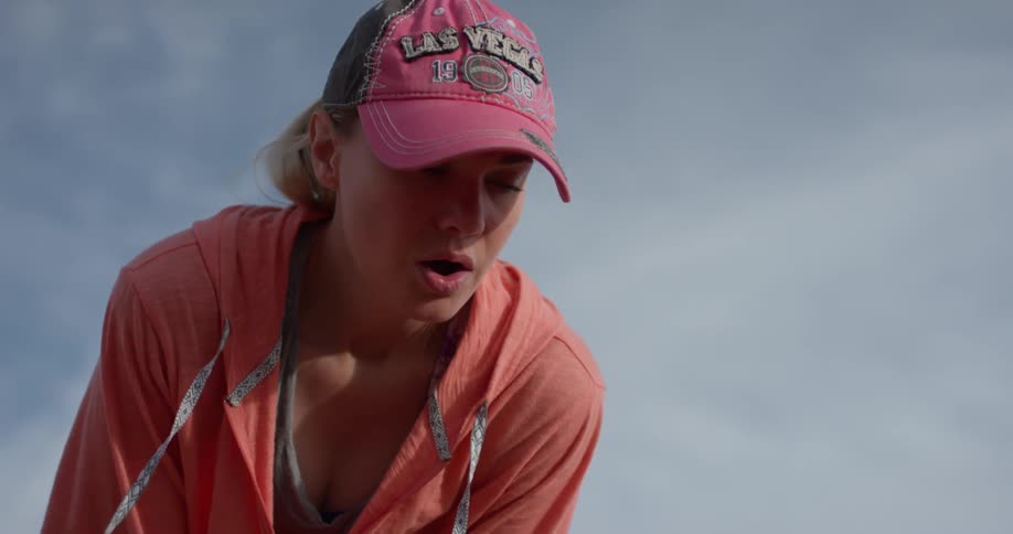 A woman bends over to catch her breath outside