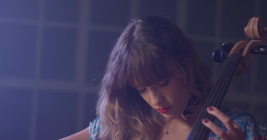 Woman plays a cello by a window with her eyes closed