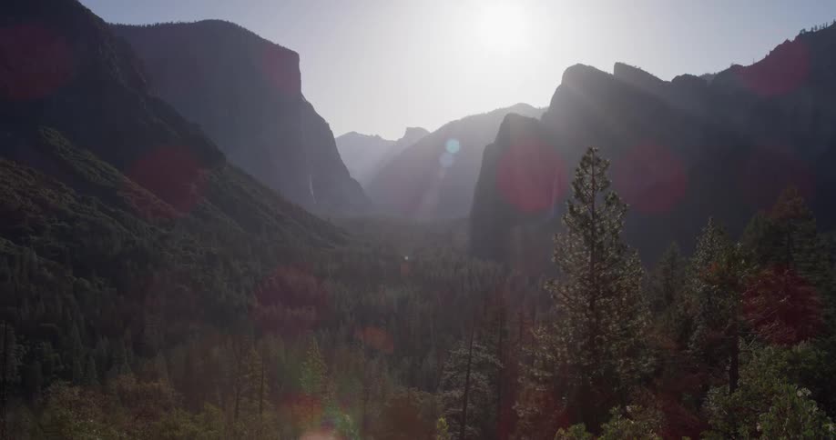 The sun is shining high above the mountain range