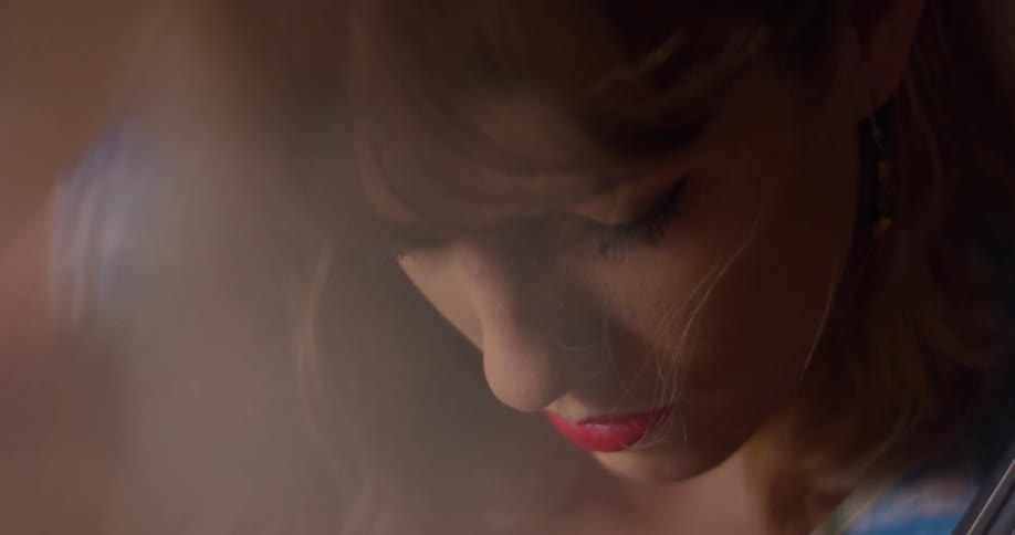 A woman looks down while she plays the cello