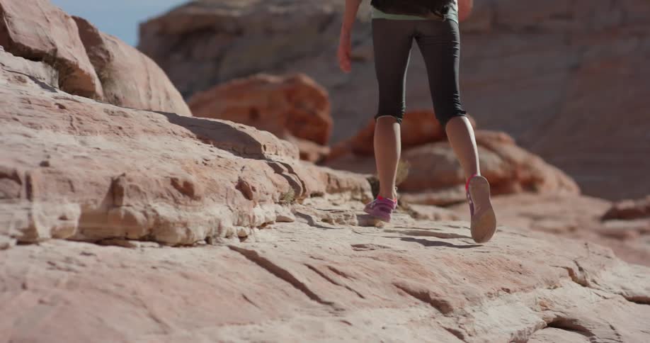 The woman walks over the rocks of the canyon