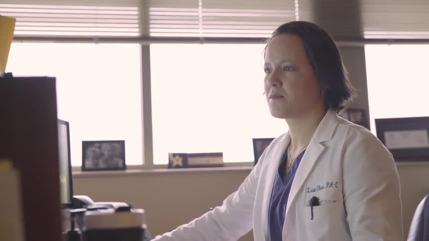 A physician works at a computer