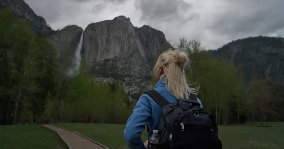 A blond haired woman hikes outside