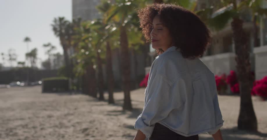 Woman walks on a large sandy area in the city