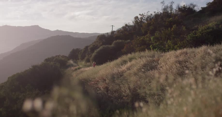 A woman jogs on a mountain path