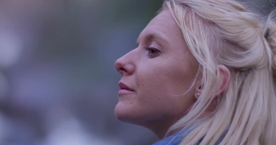 Woman stands outside in nature looking up