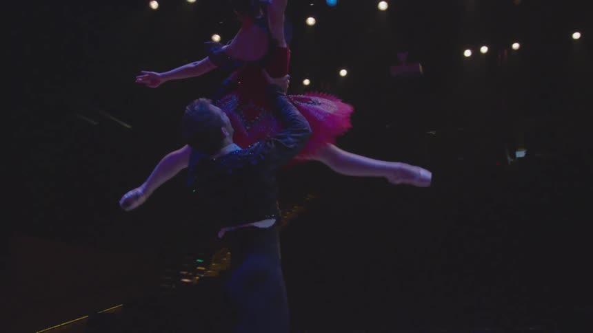 Man and woman dance on stage at night