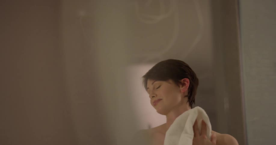 Woman dries herself off with a white towel