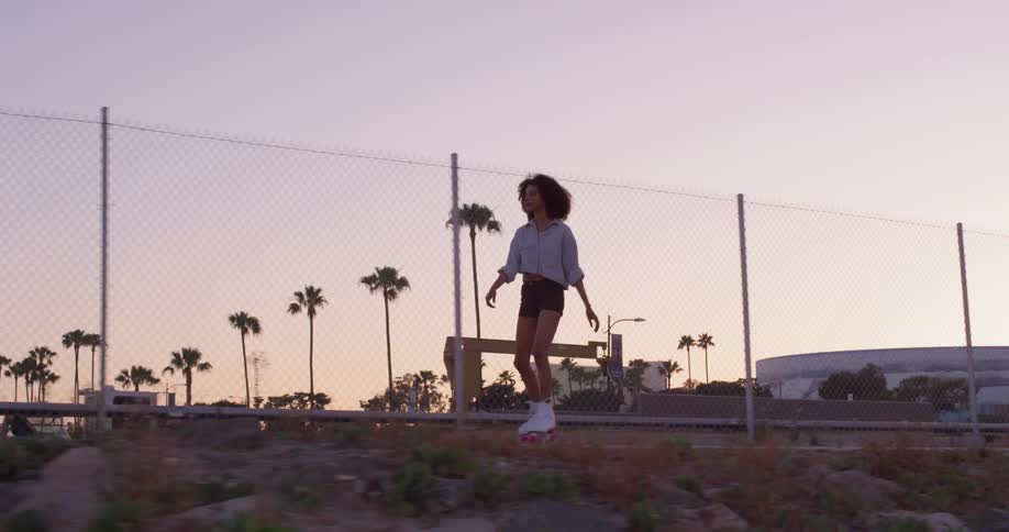 A woman roller skates at sunset