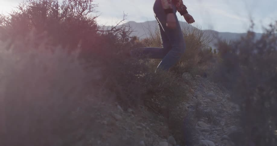 A person walks through the brush before running