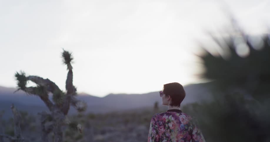 Woman stands in the desert on a sunny day